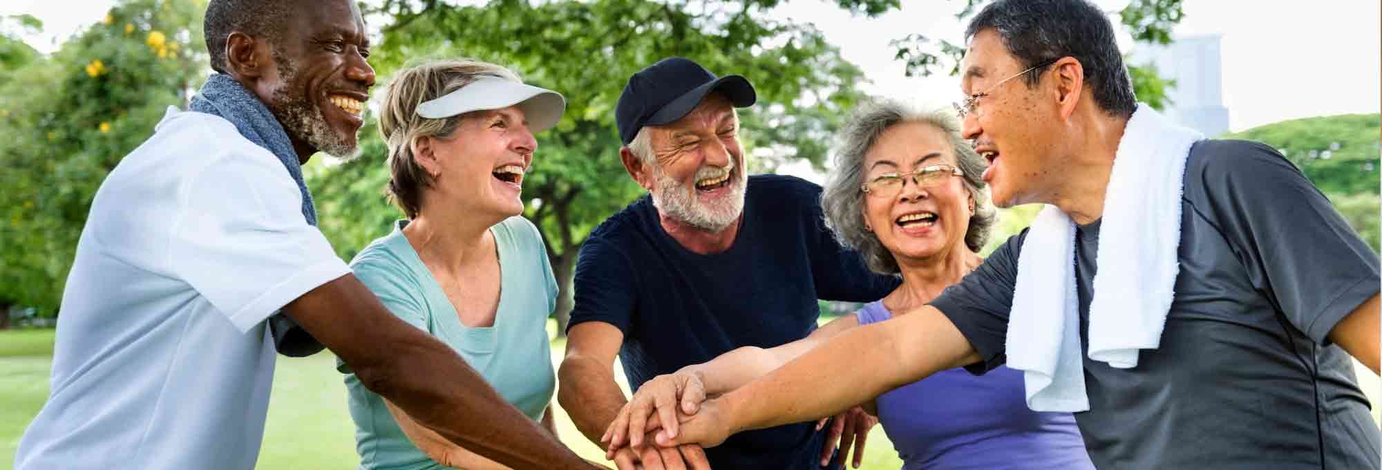 Photograph of five senior citizens enjoying time together in a park.